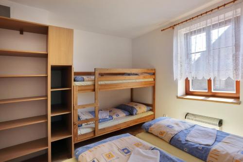 een slaapkamer met 2 stapelbedden en een raam bij Penzion Skála in Čenkovice