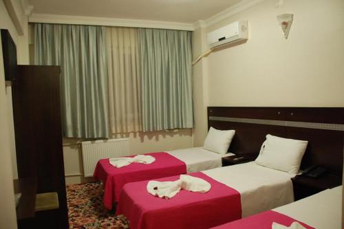 a hotel room with two beds with towels on them at Topkapı Otel Özyavuz in Istanbul
