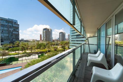 a balcony with two chairs and a view of a city at Unique Rentals-Seafront Luxe Suites in Barcelona