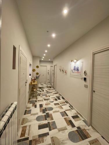 um corredor com piso em azulejo e paredes brancas em Ro&Ro Napoli luxury rooms em Nápoles