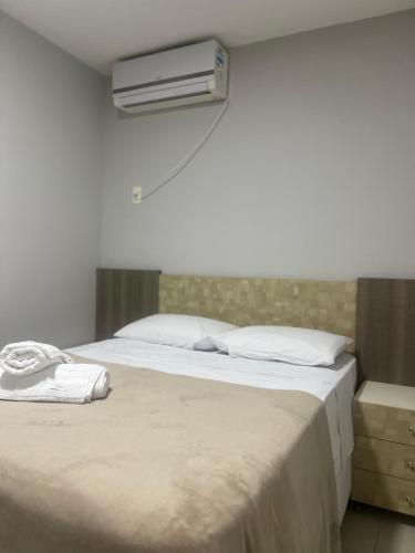 a bedroom with a bed with a air conditioner on the wall at Apartamento - 3 Quartos climatizados - By BellaEstadia in Aracaju