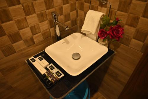 a bathroom with a sink and flowers on a counter at Swet Palash Resort in Purulia