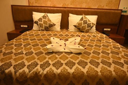 a bed with a white bow on top of it at Swet Palash Resort in Purulia