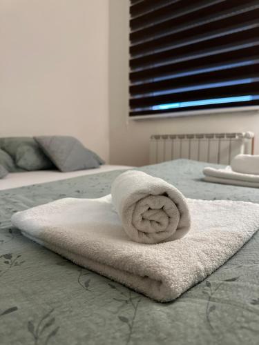 a white towel sitting on top of a bed at Čarolija in Brčko