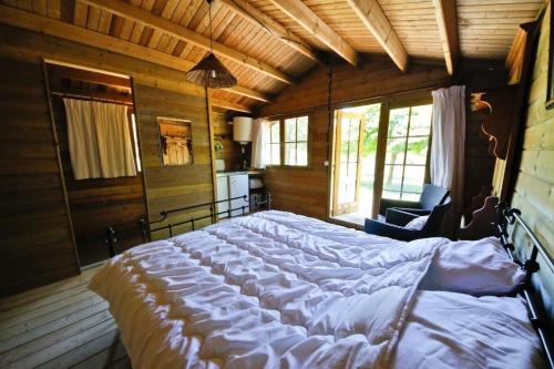 1 dormitorio con 1 cama grande en una habitación de madera en Domaine La Faix, Gite La Cigogne, en Saint-Plaisir