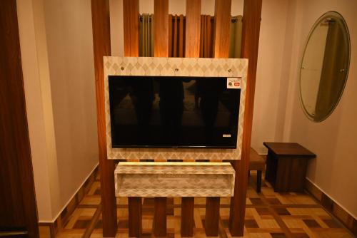 a flat screen tv sitting in a entertainment center at Swet Palash Resort in Purulia