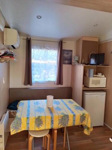 Cette petite chambre dispose d'une table et d'une fenêtre. dans l'établissement Camping, mobil home équipé proche du lac de Sainte Croix et des gorges du Verdon, à Sainte-Croix-de-Verdon