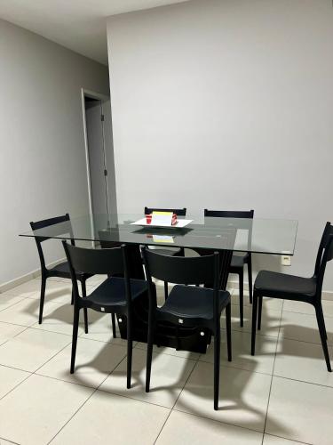 a dining room with a table and black chairs at Apartamento - 3 Quartos climatizados - By BellaEstadia in Aracaju