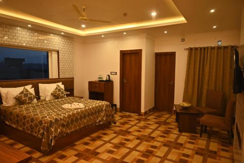 a hotel room with a bed and a chair at Swet Palash Resort in Purulia