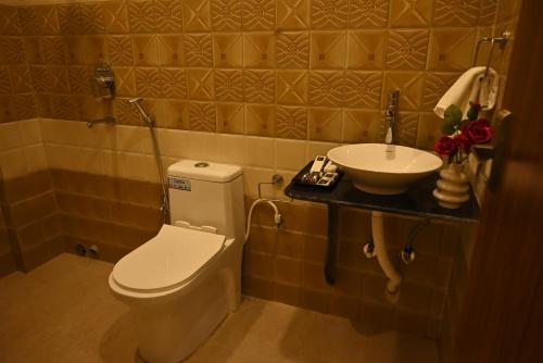 a bathroom with a toilet and a sink at Swet Palash Resort in Purulia