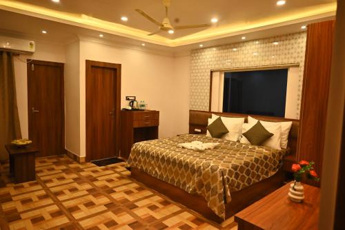 a bedroom with a bed and a flat screen tv at Swet Palash Resort in Purulia
