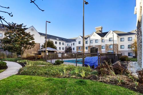 a building with a fence and a pool in a yard at Staybridge Suites Columbia - Baltimore by IHG in Columbia