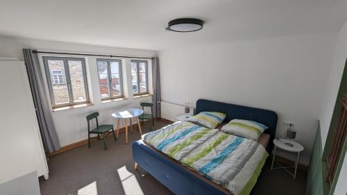 um quarto com uma cama, uma mesa e cadeiras em Gästezimmer Michelskeller em Sulzfeld am Main
