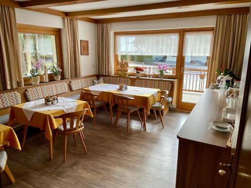 restauracja z dwoma stołami, krzesłami i oknami w obiekcie Haus Gröblacher w Mayrhofen