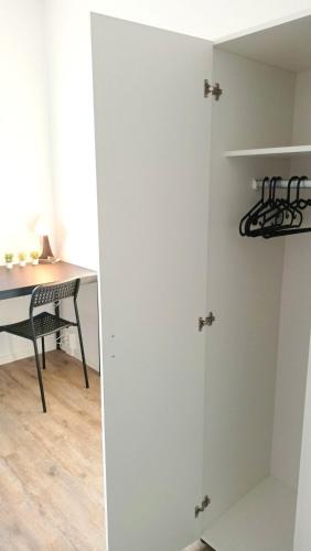 Zimmer mit einem Schreibtisch und einem weißen Schrank in der Unterkunft Apartkeep Chemnitz 234 in Chemnitz