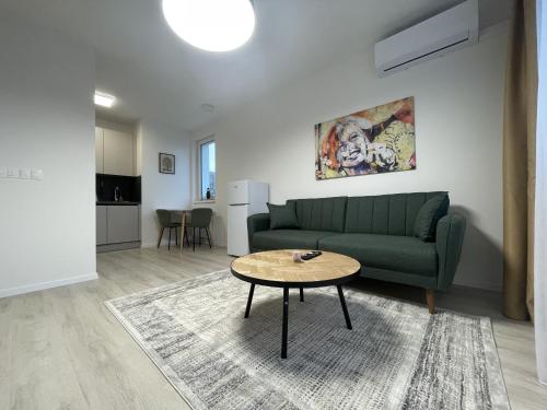 a living room with a green couch and a table at SkyNest A204 in Bratislava
