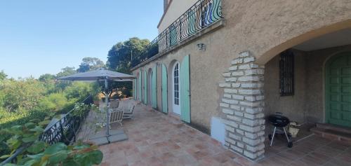 un patio avec un parasol, une table et des chaises dans l'établissement Apartment with sea/city views, near downtown Sète, à Sète