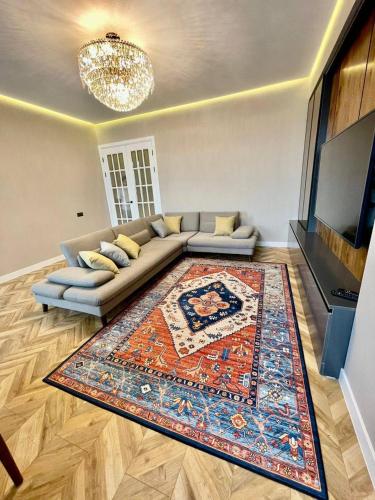 uma sala de estar com um sofá e um tapete em Designer apartment near the Gum shopping center em Bishkek