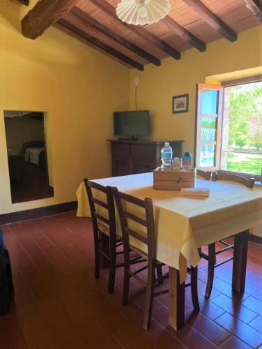 a dining room with a table and chairs at Fattoria Agriturismo Nerbona in Casole dʼElsa
