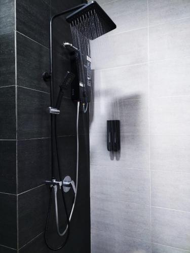 a shower with a shower head in a bathroom at SKY COZY TROIKA RESIDENCE, 1 BEDROOM 4-6 PAX, 2 BEDROOMS 6-8 PAX, POOL VEW, SKY & CITY VIEW, Free Parking, Pool, Unlimited Wifi in Kota Bharu