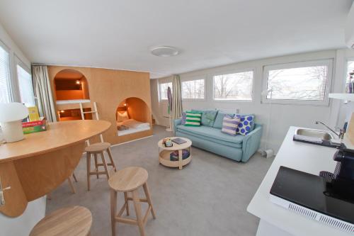 a living room with a blue couch and a table at Unique Boat Apartments by Lake - Kajuta 1958 in Námestovo