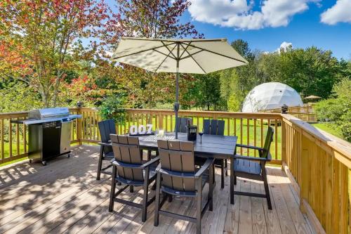 a wooden deck with a table with an umbrella at Unique Escapes - 007 Geodome in Monticello