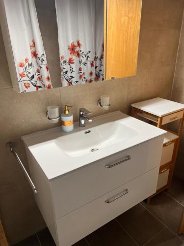 bagno con lavandino bianco e specchio di APARTAMENT ROSY a Interlaken