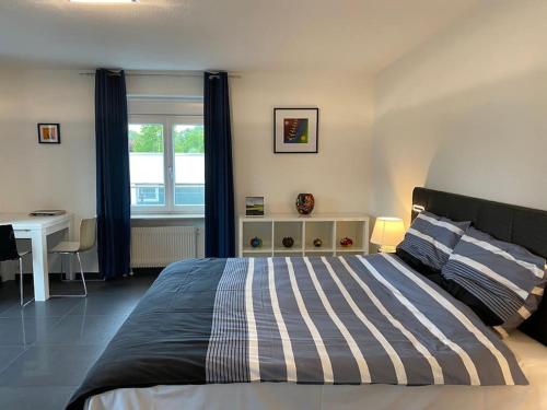 a bedroom with a bed with a desk and a window at Preiswertes stilvolles Zimmer im privaten Haus mit großem schönem modernem Gemeinschaft Badenzimmer in Lörrach