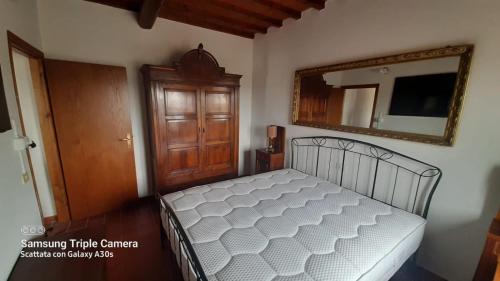 1 dormitorio con 1 cama con espejo en la pared en Aietta Tuscan Holidays, en Montaione