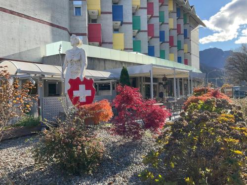 a building with a statue of a woman with a red cross at Hotel Liberty Self Check-In in Bellinzona