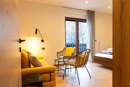 a living room with a couch and a table and chairs at My Tarvisio home in Tarvisio