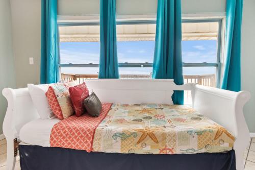 Schlafzimmer mit einem Bett mit blauen Vorhängen in der Unterkunft Breezeway in Navarre