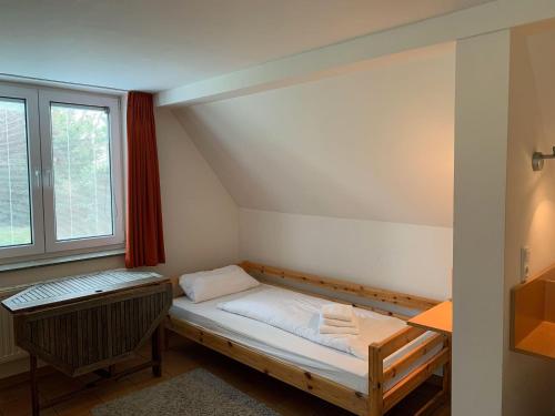 um pequeno quarto com uma cama e uma janela em Haus-Friesenstrasse-Whg-17 em Sankt Peter-Ording