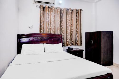 Flagship Hotel Lotus Inn في فاراناسي: غرفة نوم بسرير كبير ونافذة