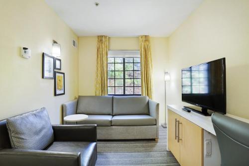 a living room with a couch and a flat screen tv at Staybridge Suites Columbia - Baltimore by IHG in Columbia