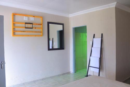 a room with a ladder and a mirror on a wall at Lis ville guest house in Phalaborwa