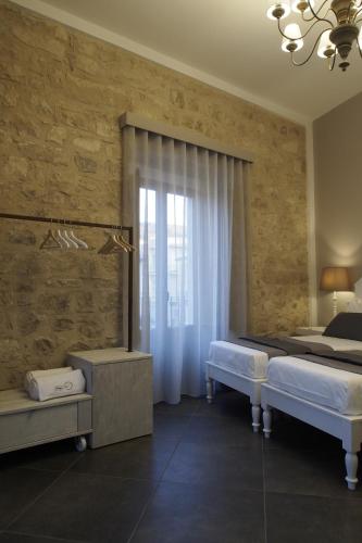 a bedroom with two beds and a window at Terrazzani Suite in Comiso