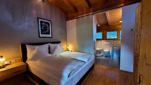 a bedroom with a large bed and a bathroom at Hotel Garni Birkenhof in Sölden