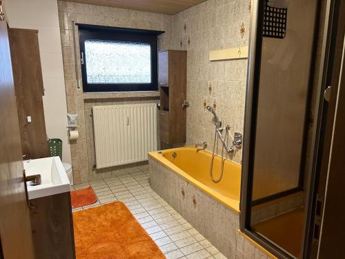 bagno con vasca gialla e finestra di Ferien- und Monteurwohnung Zum Waldblick a Wald-Michelbach