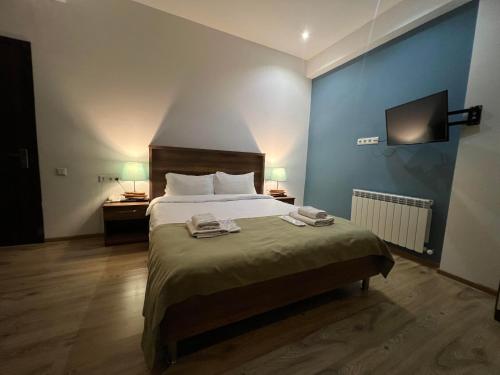 a bedroom with a bed with two towels on it at Hotel King Tom in Tbilisi City