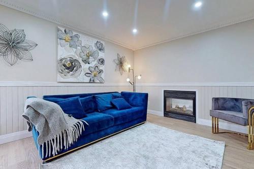 een blauwe bank in een woonkamer met een open haard bij 5 amazing bedrooms in suburban delight! in Pickering