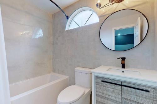 y baño con aseo, lavabo y espejo. en 5 amazing bedrooms in suburban delight!, en Pickering