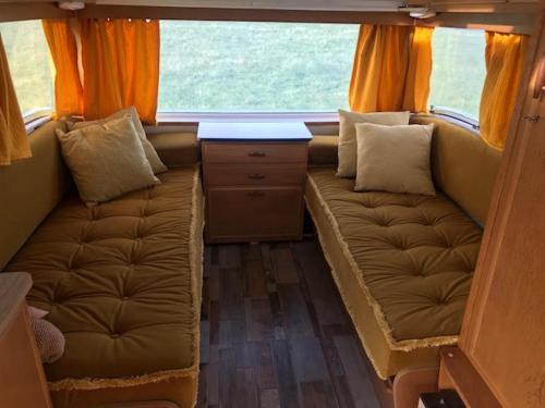 a small room with a couch and a window at The Mighty Atom - 1976 2 berth Safari Retro Caravan in Abergavenny