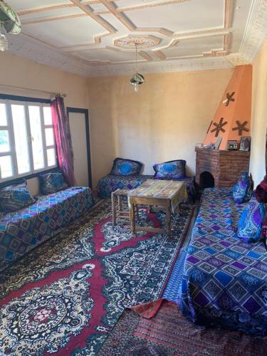 Grand Atlas Guesthouse 44 km from Marrakech في مراكش: غرفة معيشة بها كنب وطاولة وسجادة