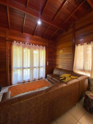 a living room with a couch and a window at Sítio da Paz - Pinheira Sc in Palhoça