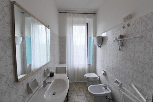 a white bathroom with a sink and a toilet at Fattoria Agriturismo Nerbona in Casole dʼElsa