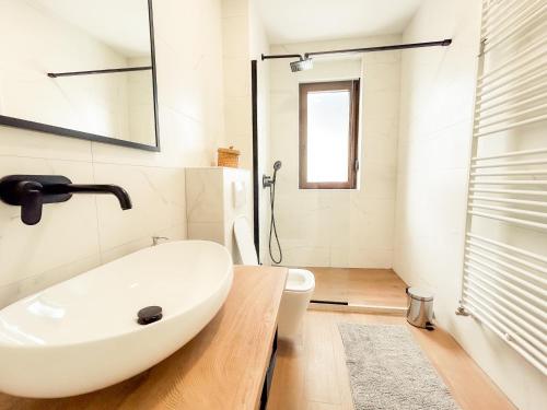 a bathroom with a white sink and a shower at Villa verde leisure apartment in Tarvisio