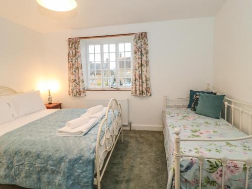 a bedroom with two beds and a window at Two Towers Cottage in Montacute