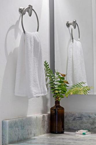 a bathroom with white towels and a vase with a plant at Las Olas Blvd Waterfront Apt in Fort Lauderdale