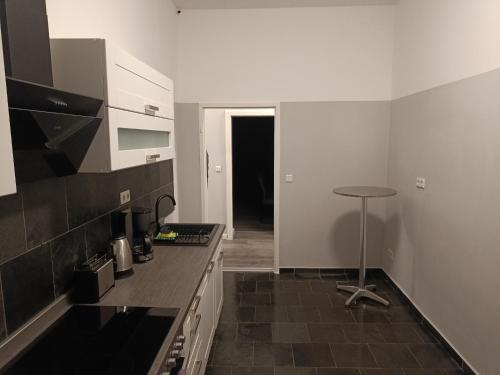 una cocina con encimera y taburete. en City-Apartment Schöneweide, en Berlín